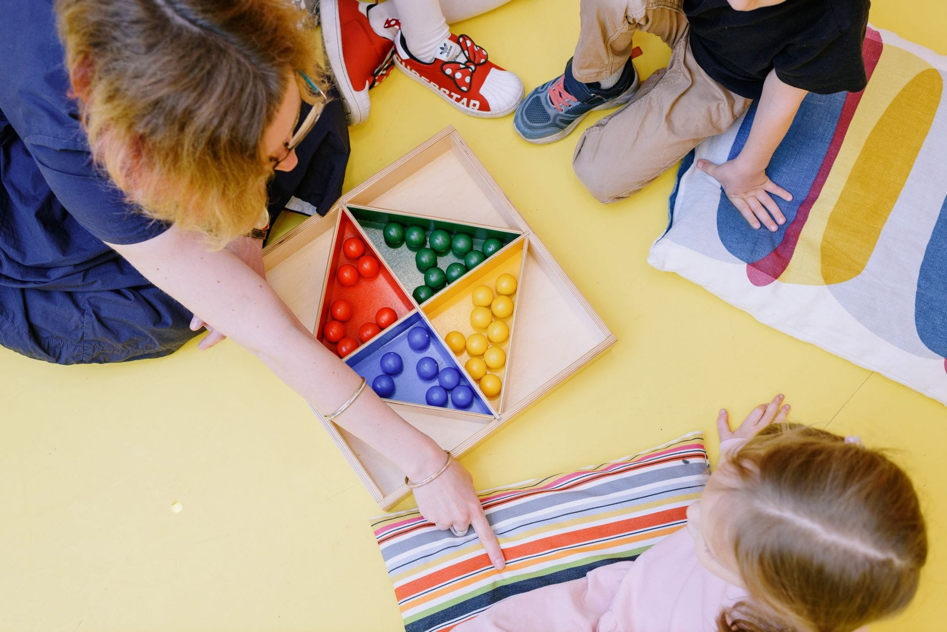 Dzieci w żłobku grają razem w kolorową grę edukacyjną